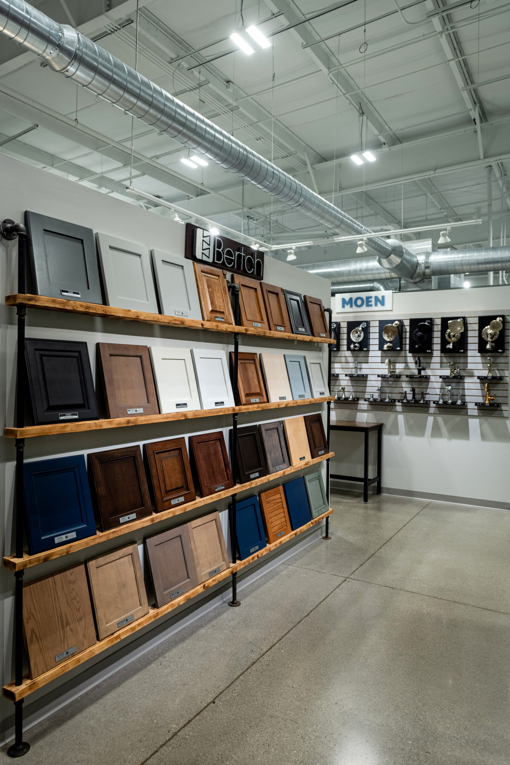 A showroom from a leading bathroom remodeling company in Columbus, Ohio displays cabinet door samples in various colors and finishes. In the background, another display labeled “MOEN” showcases faucets—perfect inspiration for your kitchen remodel.